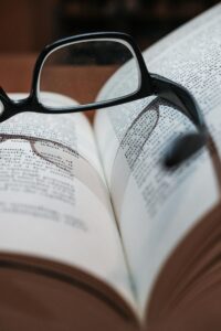 Eyeglasses resting on an open book, highlighting focus and depth of field.