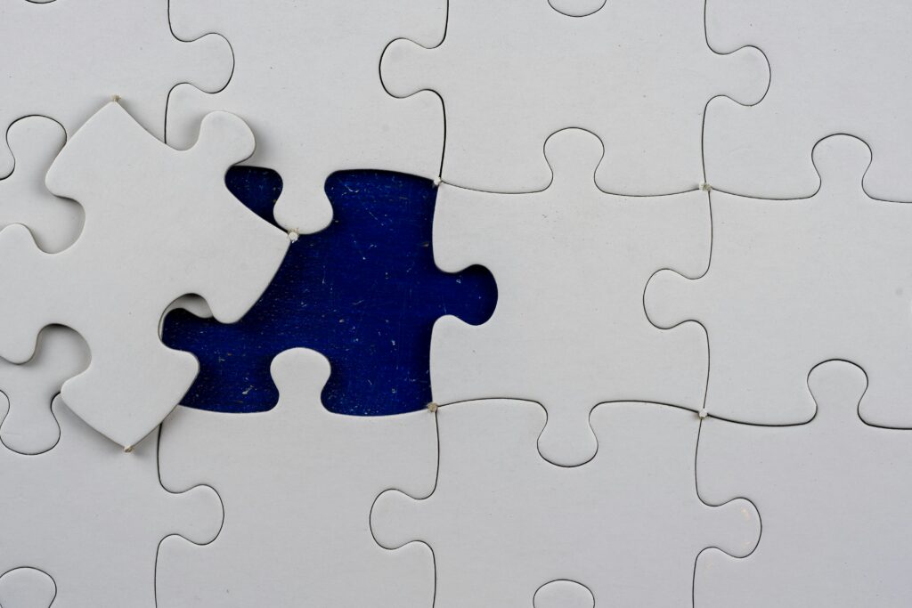 An artistic close-up of a puzzle with one missing piece revealing a contrasting background.